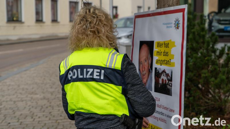 Eine Polizistin bringt das Fahndungsplakat in der Nähe des Wernberger Marktplatzes an. Bild: sbö