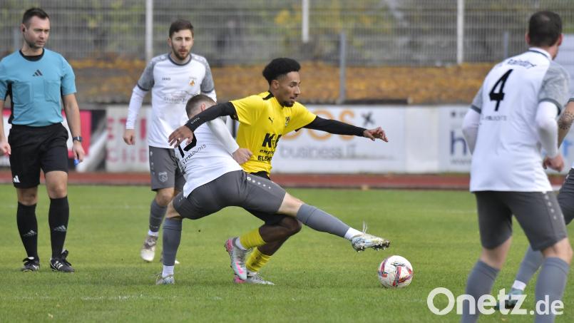 Jamairo Carswell (gelbes Trikot) vom FC Amberg behauptet sich im Zweikampf gegen Gegenspieler vom FC Raindorf. Bild: Hubert Ziegler