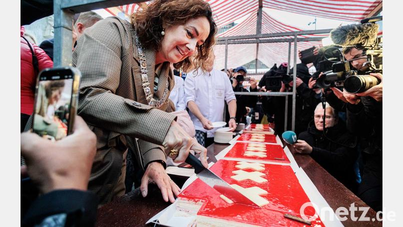 Amsterdams Bürgermeisterin Femke Halsema schneidet die lange Torte an. Bild: Ramon Van Flymen/ANP/dpa