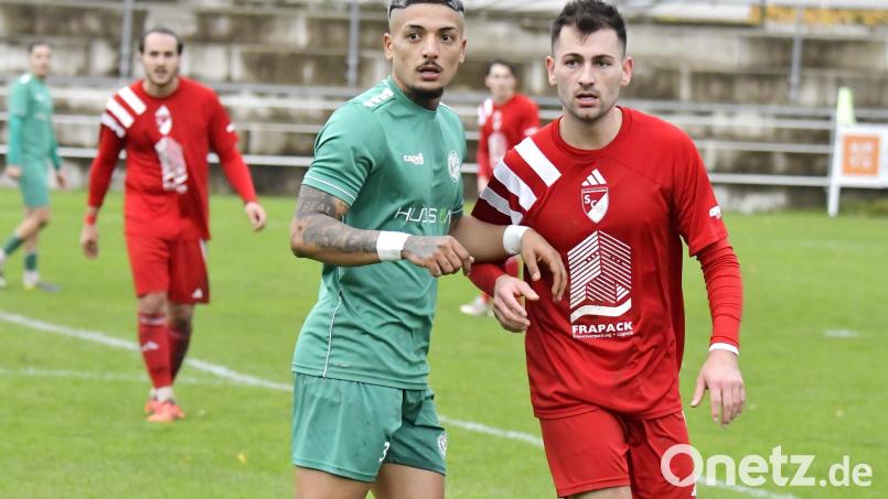 Immer dran am Mann: Ertugrul Er (grünes Trikot) von der DJK Gebenbach am Samstag beim Spiel gegen den SV Großschwarzenlohe. Bild: Hubert Ziegler