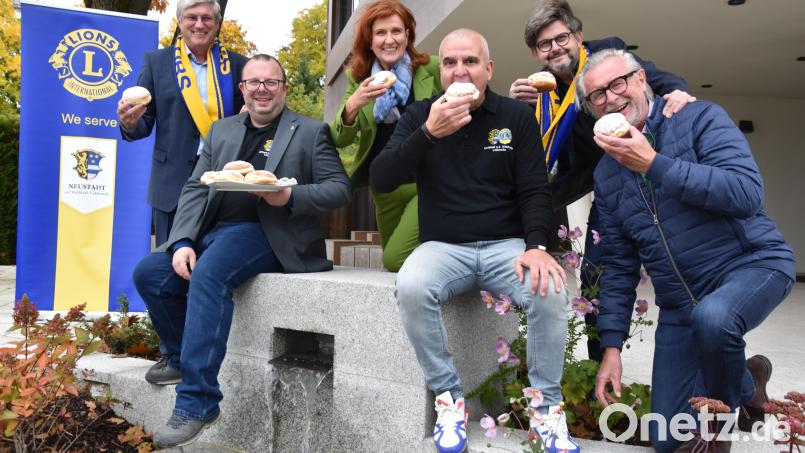Beherzter Biss in einen süßen Krapfen – und damit Herz zeigen. Zum sechsten Mal organisieren die Lions unter Federführung von Präsident Sebastian Denzler (vorne, links), Vize-Präsident Peter Fleischmann (vorne, Mitte) und Vorsitzendem des Hilfswerks Klaus Berberich (vorne, rechts) die traditionelle Krapfen-Aktion. Bild: Lions Club Neustadt/WN