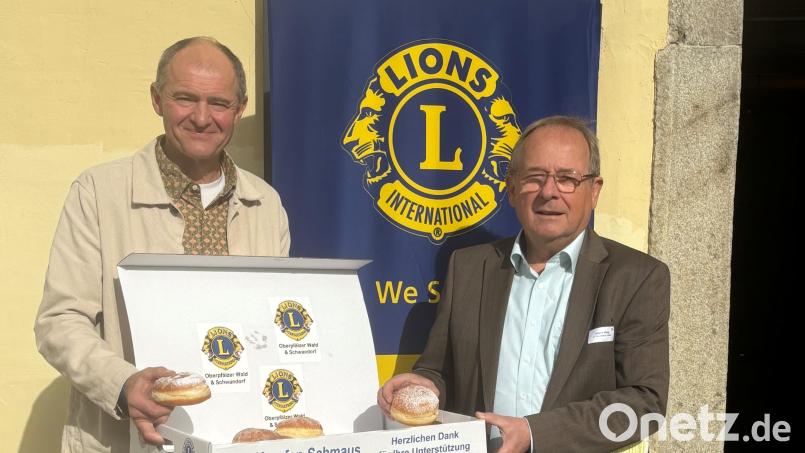 Zum Reinbeißen: Die Lions-Präsidenten Hans Klug (rechts) und Alexander Heinz (links) probieren die Krapfen. Bild: Lions Oberpfälzer Wald/Diana Neidhardt