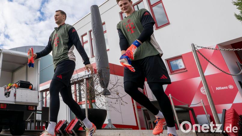 Torwart Manuel Neuer (l) und Ersatzkeeper Jonas Urbig auf dem Weg auf den Trainingsplatz. Bild: Peter Kneffel/dpa