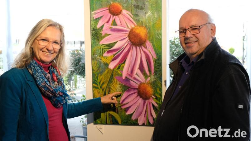 Was sollte besser in die gärtnerische Landschaft eines Pflanzbetriebes, wie der Gärtnerei Ziereis passen, als ein farbenfrohes Gemälde einer "Echinacea purpurea"? Links die Künstlerin Marion Eschenbecher, rechts Gärtnermeister Hannes Ziereis, in dessen Räumen die Ausstellung stattfindet. Bild: mab