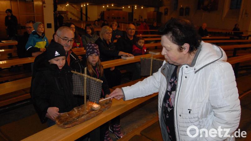Mesnerin Claudia Kraus entzündet in der Kirche die Kerzen der Schiffchen. Bild: pop