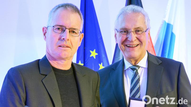 Der Bayerische Innenminister Joachim Herrmann überreicht Uwe Dressel (links) das Ehrenzeichen. Bild: Bayerische Staatskanzlei