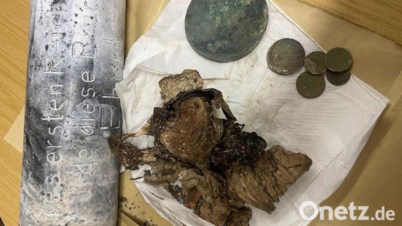 Silber- und Kupfermünzen, ein Zeitungsartikel und Fotos wurden seit dem beim Bau einer Brücke in Hof im Jahr 1928 in einer Zeitkapsel aufbewahrt. Nun sind die Gegenstände beim Abriss des Bauwerks wiedergefunden worden. Bild: -/Stadt Hof/dpa