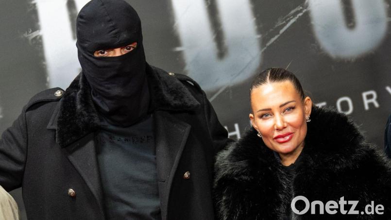 Haftbefehl (bürgerlich Aykut Anhan und hier verhüllt) besucht mit seiner Frau Nina Anhan eine Kinoaufführung der Dokumentation „Babo - Die Haftbefehl-Story“ in Berlin. (Archivbild) Bild: Christophe Gateau/dpa