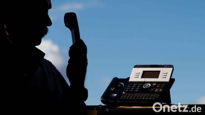 Ein Betrüger gab sich am Telefon als Polizeibeamter aus, um an Bargeld zu kommen. (Symbolbild) Bild: Julian Stratenschulte/dpa