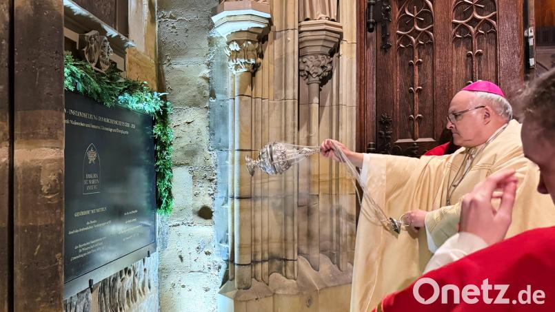 Die Tafel am vorderen Portal der Südseite der Martinskirche, die die Förderer der Sanierungsmaßnahmen nennt, wurde von Bischof Dr. Rudolf Voderholzer am Ende des Gottesdienstes gesegnet. Bild: Peter Ringeisen