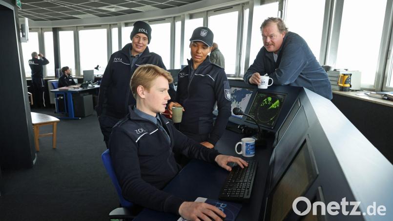 Zöllner Sven-Erik Dröse (Lukas Zumbrock, sitzend) kommt einer heißen Spur auf die Schliche in einer Szene aus der Folge „Geschäft mit dem Tod“ aus der Krimireihe „Der Bremerhaven-Krimi“ - hinten von links nach rechts: Elena Uhlig, Cynthia Micas, Bernd Hölscher. Bild: Jörg Landsberg/Radio Bremen/ARD/dpa