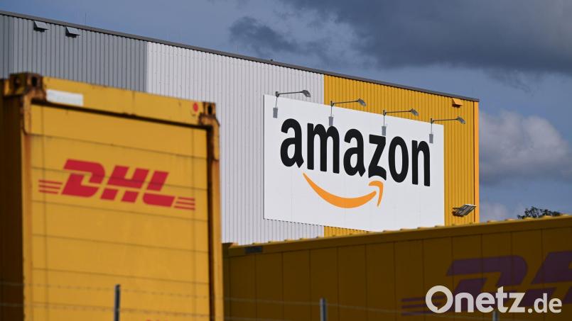 Ein Logistikzentrum von Amazon, auf dessen Gelände DHL-Container stehen. DHL ist das größte Paketunternehmen in Deutschland, gefolgt von Amazon - der Online-Handelsriese trägt einen großen Teil bei ihm bestellten Waren selbst aus. (Archivbild) Bild: Wolf von Dewitz/dpa