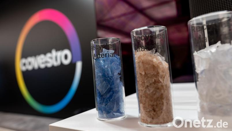 Eine deutsche Firma wird arabisch: Das Logo des Spezialchemie-Konzerns in einem Firmen-Showroom, davor Gläser mit Covestro-Materialien. Bild: Fabian Strauch/dpa