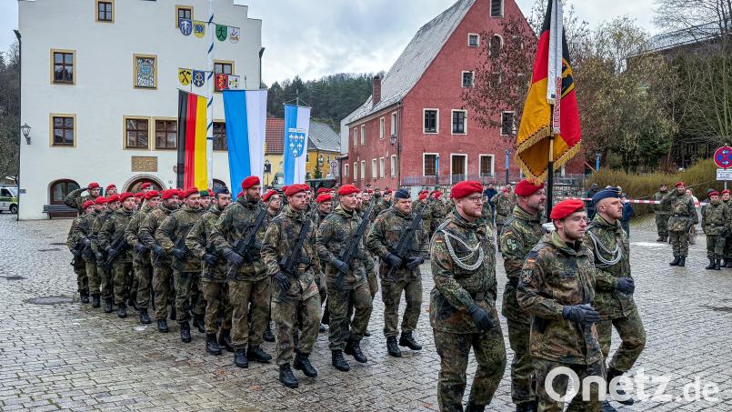Truppenfahne und Ehrenzug marschieren voraus, es schließen sich Abordnungen der einzelnen Kompanien des Logistikbataillons an: Am Marktplatz in Kastl legten Rekruten ihr Gelöbnis ab – anfangs noch ohne Regen und Graupelschauer. Bild: Stephan Huber