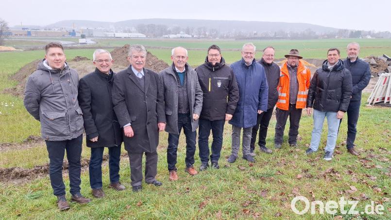 Vertreter der drei Kommunen, des Landkreises und der ausführenden Baufirma Sommer vor dem Hintergrund von A 93 und einem Teil der zukünftigen Gewerbeflächen. Bild: Michael Weiß/VG Wackersdorf