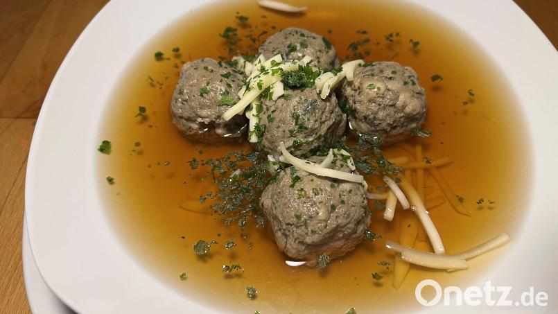 Die Klößchen werden in die köchelnde Bouillon gegeben, kurz gar ziehen lassen. Serviert wird mit Petersilie und Käsestreifen. Bild: Michael Schiffer