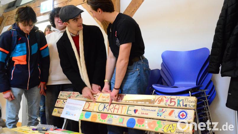 Schüler des Kepler-Gymnasiums betrachten eine der drei bemalten &quot;Demokratie-Bänke&quot;. Bild: Kunz
