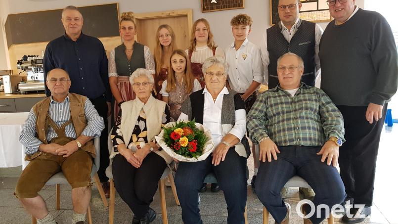 Monika Grünbauer (mit Blumenstrauß) feiert 85. Geburtstag. Dazu gratulieren ihre Söhne Anton (links) und Georg (rechts), ihre Schwägerin Annelies Frank sowie ihre Enkel und Urenkel. Glückwünsche überbringen Pfarrer Udo Klösel (rechts) und Bürgermeister Helmut Meindl (stehend, links). Bild: gi