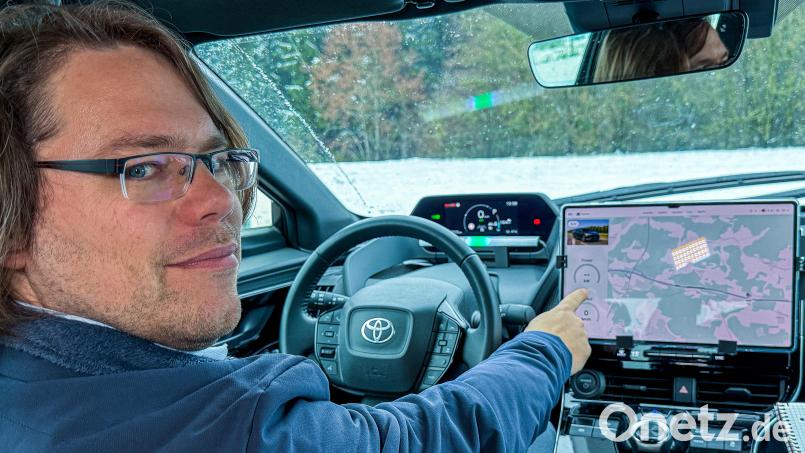 Andreas Wendt am Steuer des Testfahrzeugs. Hier erklärt er, wie das induktive Laden funktioniert. Bild: Stephan Huber