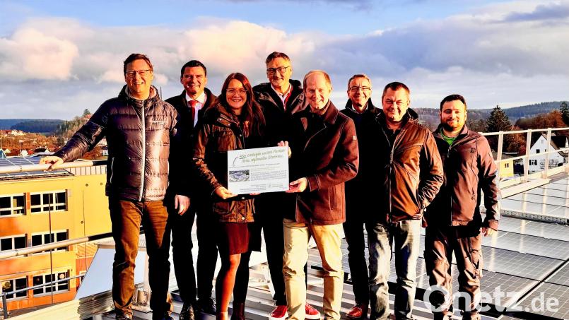 Am Dach der Sporthalle stellen sie das neue regionalen Stromkonzept vor (von links): Wolfgang Dumm vom Bayernwerk, Landrat Thomas Ebeling, Christina Barchmann von der Bayernwerk Regio Energie, BEMO-Vorstand Hans Prechtl, Bürgermeister Konrad Kiener, Thomas Oppelt Geschäftsführer Bayernwerk Regio Energie sowie die beiden Hausmeister Hans-Peter Geitner und Fabian Schinner. Bild: Wolfgang Geitner