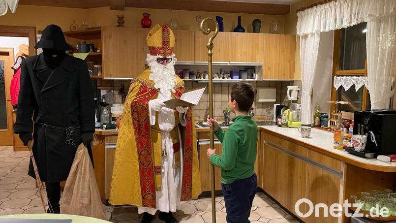 Der Nikolaus besucht am 5. Dezember zusammen mit dem Krampus auch die Familien rund um Teunz. Während er aus seinem goldenen Buch vorliest, dürfen die Kinder den Bischofsstab halten. Archivbild: Feuerwehr Teunz