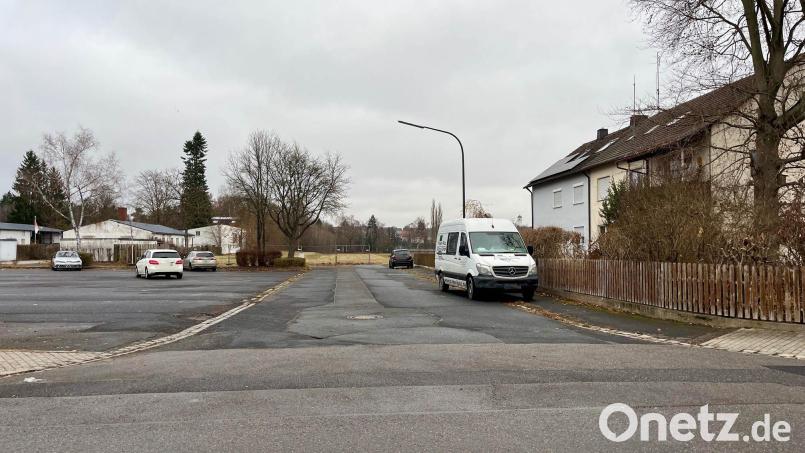 Über diese Stichstraße neben dem Parkplatz (links) soll später das neue Wohnquartier auf dem ehemaligen Sportplatz der SV Detag angefahren werden. Umliegende Anwohner haben Sorge, dass die Einmündung zur viel befahrenen Königsberger Straße (im Vordergrund) damit zur Gefahrenstelle werden könnte. Bild: Gabi Schönberger