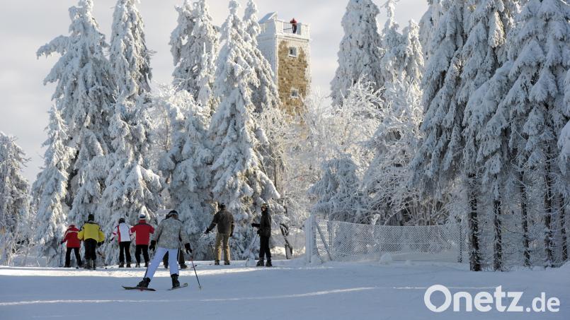 Skifahrer laufen auf dem Ochsenkopf bei Bischofsgrün im Fichtelgebirge am Asenturm vorbei. Archivbild: David Ebener, dpa