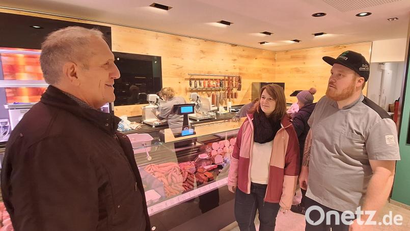 Bürgermeister Werner Prucker (links) sah am ersten Verkaufstag in der neuen Metzgerei vorbei und plauderte mit Metzger Tobias Grünbauer (rechts) und dessen Frau Stephanie. Bild: fks