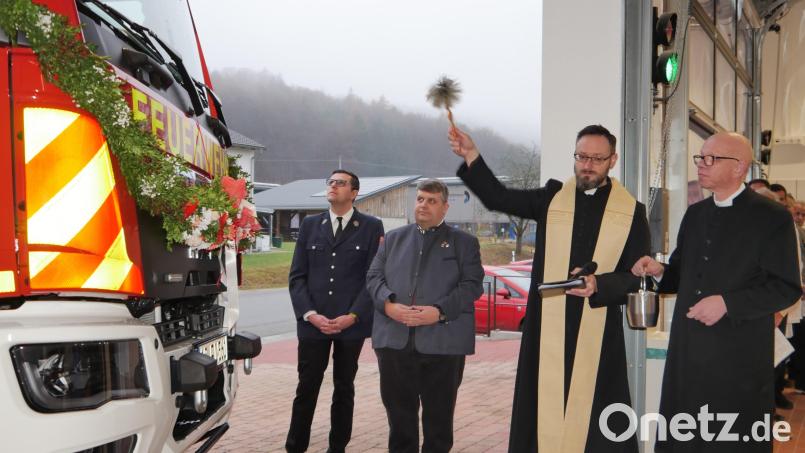 Der katholische Pfarrer Johannes Arweck segnet, unterstützt vom evangelischen Pfarrer Thomas Schertel, das neue, geschmückte Einsatzfahrzeug, beobachtet vom 1.Bürgermeister Dieter Dehling und dem Kommandanten der Feuerwehr Illschwang Thorsten Jobst Bild: no
