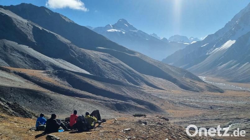 Bei Dunkelheit und Kälte loszumarschieren kostet Überwindung. Doch wenn die Morgensonne über den Gipfeln aufgeht, entstehen famose Bilder. Die Sonne wärmt schnell und gibt Kraft. Hier macht die Gruppe auf einem Plateau Pause und schaut auf die zurückgelegte Strecke. Bild: Toni Müller