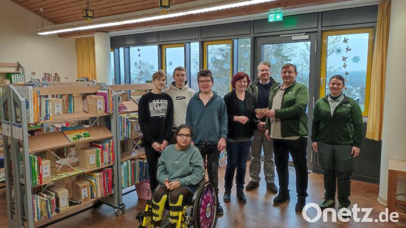 In der neu eingerichteten Bibliothek des Heilpädagogischen Zentrums wird die Spende von Herrn Arnold an die Förderschule übergeben.“ (von links: Schüler der Förderschule, Petra Rothmund, Sonderschulrektorin, Philipp Bahnmüller, Leiter Staatsforstbetrieb Schnaittenbach, Ludwig Arnold, Inventurleiter Nord Bayerische Staatsforsten und Christiane Arnold, Leiterin Staatsforstrevier Hessenreuth West) Bild: Konstantin Bayer