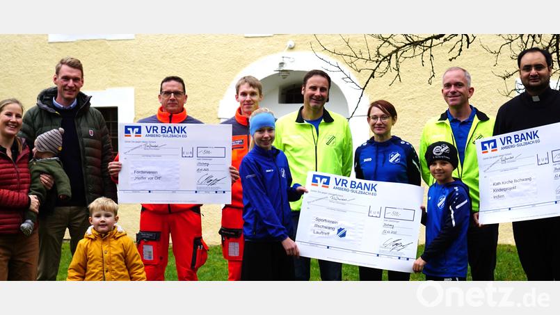 Übergabe der drei Spendenschecks: (von links) Christoph Margraf mit Ehefrau Lisa und den Kindern Franz und Eva, Thomas Renner und Hendrik Huber vom Verein "Helfer vor Ort Illschwang/Birgland", Eberhard Luber, Helga Jana Jens Grahlmann, mit den Kindern Larissa Grahlmann und Jonathan Binder vom Kinderlauftreff des SV Illschwang und Pfarrvikar Yeruva. Bild: no