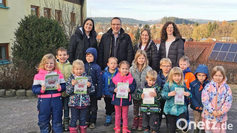 Die Teunzer Kinder und Leiterin Simone Kraus (links) freuen sich über das Abenteuerbuch, welches unter der Regie des Kinderhaus-Elternbeirates mit Vorsitzendem Martin Pflug, dessen Vorgängerin Simone Kraus und Teammitglied Elisabeth Birner (rechts) entstanden ist. Bild: Portner