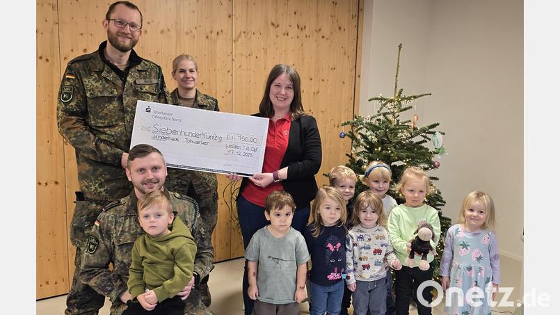 Major Mieth, Oberfeldwebel Wicke (hinten von links) sowie Stabsunteroffizier Wagner mit Sohn Leo (vorne links) überreichen einen symbolischen Scheck an Leiterin Franziska Lang. Mit im Bild Kinder des Kinderhauses Tonwerker, die sich schon auf neues Spielzeug freuen. Bild: Anna König
