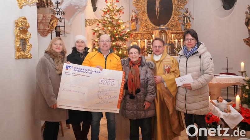 5000 Euro gibt es für die Renovierung der Vohenstraußer Pfarrkirche und 200 Euro für den Pleysteiner Kindergarten. Christa Wildenauer überreichte die Spenden an Pfarrer Alexander Hösl und die Kirchenverwaltung sowie Beate Schuch (rechts). Bild: Franz Völkl
