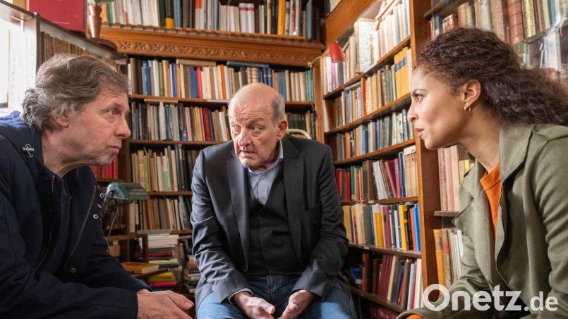 Teambesprechung zwischen Bücherregalen bei „Wilsberg“. Bild: Thomas Kost/ZDF/dpa