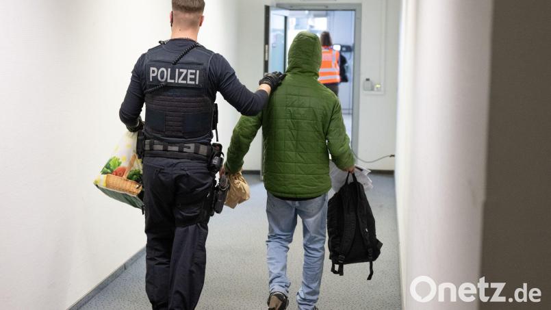 Ein Polizeibeamter bringt einen Mann zu einem Abschiebeflug nach Pakistan. (Archivfoto) Bild: Boris Roessler/dpa
