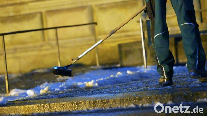 Ein Mann räumt Schnee vor der Alten Pinakothek in München. In der Nacht soll es wieder kälter werden, mit Schneefall bis in die Niederungen. Bild: Malin Wunderlich/dpa