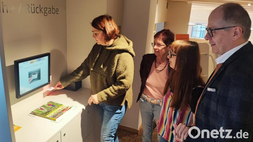 Ausweis unter den Strichcodescanner halten, bis zu fünf Medien in ein gekennzeichnetes Feld legen und den Anweisungen am Bildschirm folgen: Judith Schliermann demonstriert Christine Schubert, Deborah Pregler und Bürgermeister Roman Schäffler (von links), wie Ausleihe und Rückgabe am Verbuchungsgerät funktionieren. Bild: luk