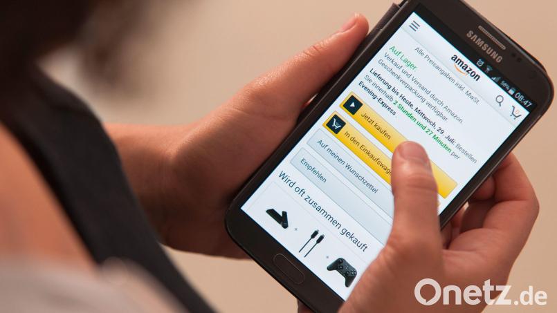 Eine Frau bedient die Smartphone-App des Onlinehändlers Amazon. Symbolbild: Sebastian Gollnow/dpa