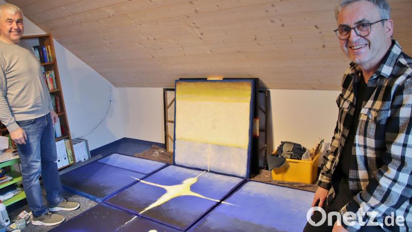 Künstler Markus Pleyer (rechts) und Kirchenpfleger Günter Schießl in Pleyers Atelier in Wolfring. Das Fastenbild besteht aus fünf quadratischen Gemälden, jedes einen Quadratmeter groß. Die Holzrahmen der einzelnen Tafeln werden verschraubt, dann kann das kreuzförmige Kunstwerk in der Albertus-Magnus-Kirche in Fensterbach aufgehängt werden. Bild: Thomas Dobler
