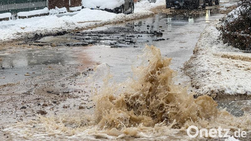 Minutenlang strömte das Wasser schwallartig aus dem Boden und überschwemmte Teile der Bahnhofstraße. Im Hintergrund ist zu sehen, dass der Asphalt auf mehreren Metern Länge aufgebrochen ist. Bild: Petra Hartl