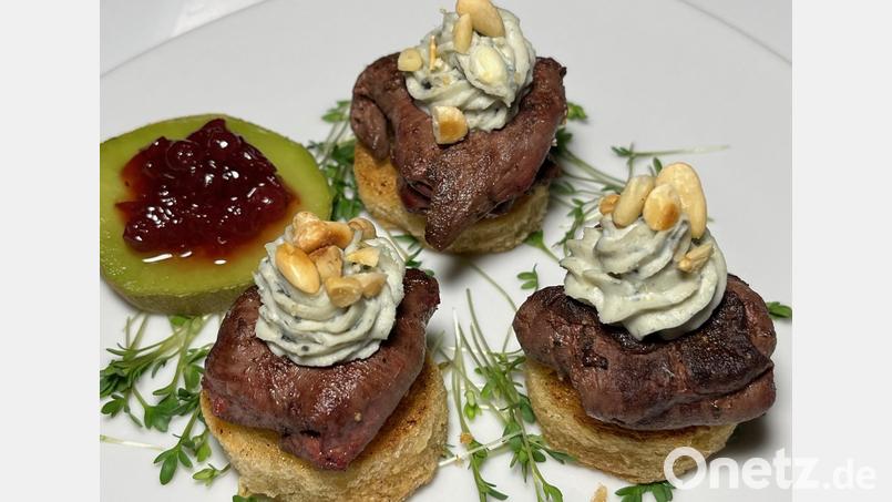 Die Hasenfilets mit Calvadoskäse werden zum Servieren auf rundes Toastbrot platziert und mit Kresse bestreut. Bild: Michael Schiffer