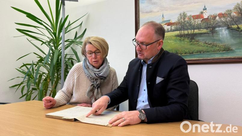 Kassenführerin Ulrike Schiller und Bürgermeister Richard Kammerer blättern im ersten Protokollbuch, das die Jahre 1926 bis 1957 umfasst. Bild: Ulrike Fuhrmann