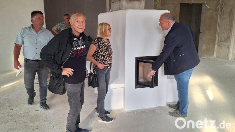 Ein Kachelofen soll in der Gaststube für ein gemütliches Ambiente sorgen. Bürgermeister Werner Prucker (rechts) testet die Ofentür. Bild: fks
