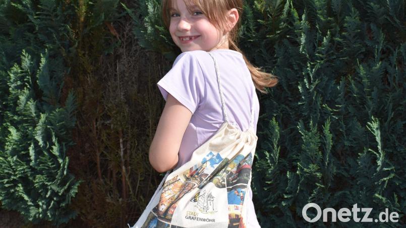 Aus einer Einkaufstasche entstand dieser Rucksack mit Bildern aus Grafenwöhr. Luise Rahn hat ihn gefertigt. Ihre Urenkelin Emmy hat sich als Model zur Verfügung gestellt. Bild: rgr