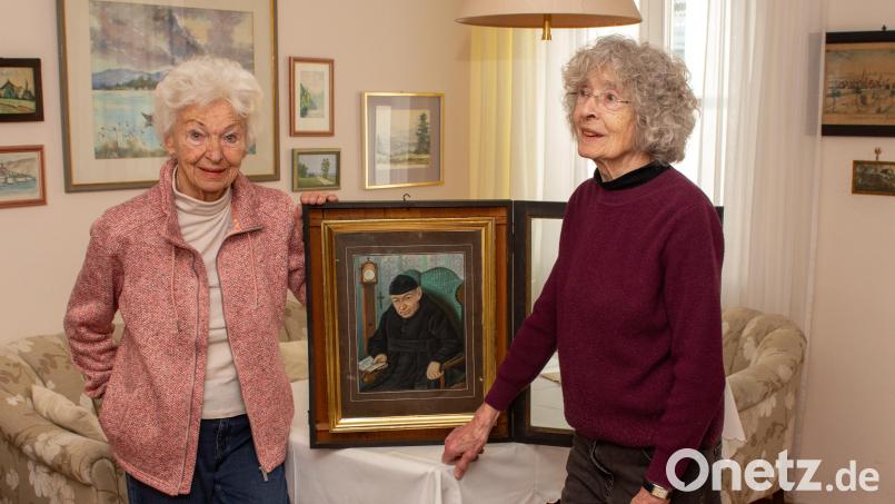 Gunda Eckert (links) und Annemarie Doyscher mit dem Originalbild von Pater Benedikt Üblacker. Überraschung: Es ist farbig. Laut Annemarie Doyscher gibt es die Standuhr auf dem Bild hinten links immer noch, sie wird nach wie vor in Ehren gehalten. Bild: Thomas Sporrer
