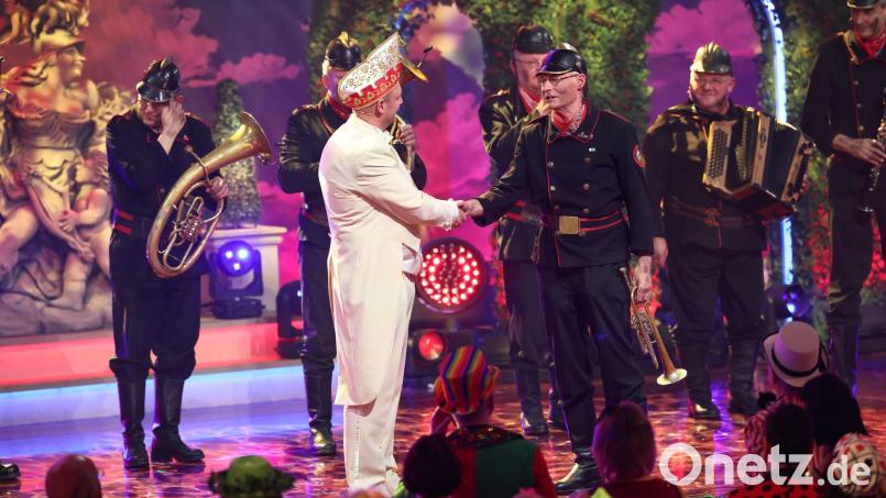 Sitzungspräsident Christoph Maul (links) verabschiedet sich von Norbert Neugirg und seiner „Altneihauser Feierwehrkapell’n“, die nach 20 Jahren zum letzten Mal bei „Fastnacht in Franken“ auftrat. Bild: Daniel Löb/dpa