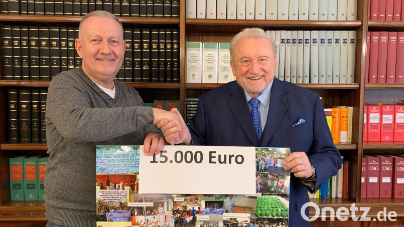 Bei der Spendenübergabe zeigte Dr. Ulrich Schmid (rechts) ein Plakat mit Fotos von vielen Projekten, die er auf den Philippinen schon unterstützt hat. Darüber freute sich keiner mehr als Projekthilfe-Vorsitzender Thomas Amann (links), der auch die frisch gestifteten 15.000 Euro wieder auf den Philippinen einsetzen will. Bild: Corina Mack