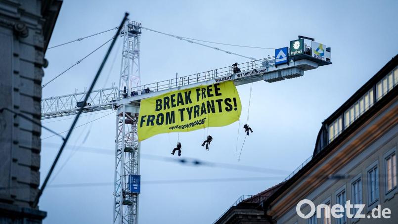 Aktivisten seilen sich von einem Kran in der Nähe der Münchner Sicherheitskonferenz ab. Bild: Kay Nietfeld/dpa